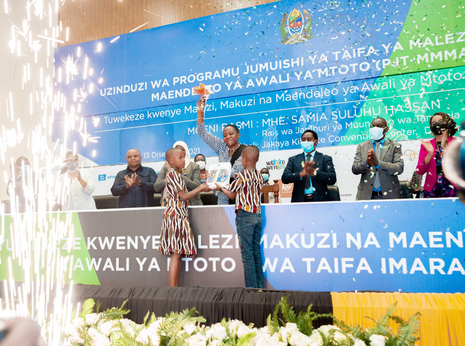 Image of launch of NMECDP event held in Tanzania - firework going off and children presenting plague